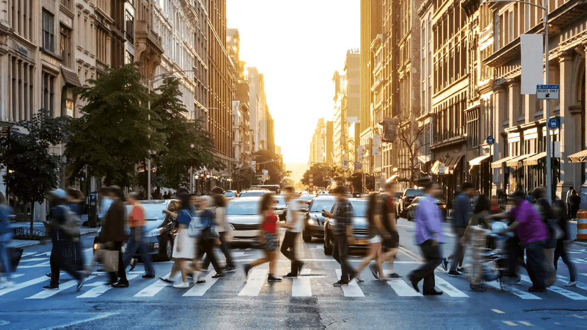 A crowd of people crossing a city street